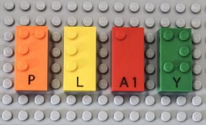 Imagen de Legos con braille construyendo la palabra jugar en inglés