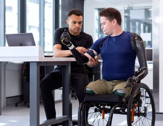 Persona usuaria de sillas de ruedas con amputación de miembros inferiores y prótesis en miembros superiores