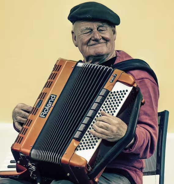 Hombre mayor tocando un acordeón. Imagen de Pexels.