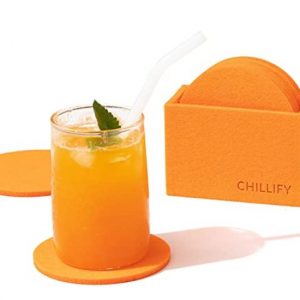 Posavasos de color naranja junto a un vaso con zumo de naranja