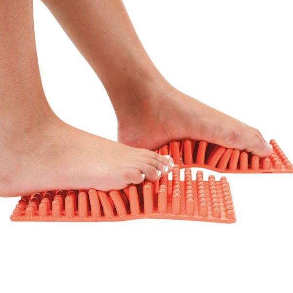 pies sobre alfombra de masajes naranja